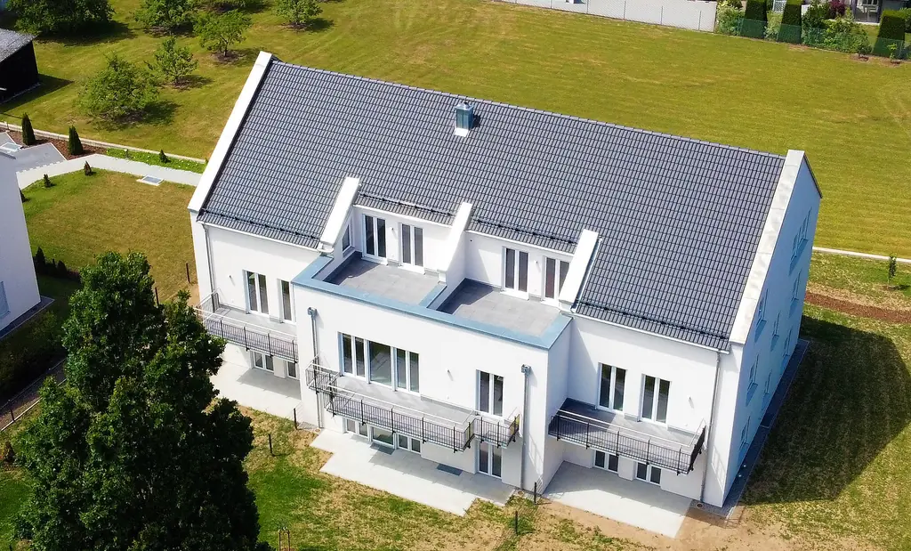 Luftaufnahme einer neu gebauten Reihenhauszeile mit Dachterrassen