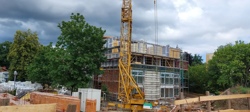 Ziegelrohbau eines Geschosswohnungsbaus mit Turmdrehkran auf der Baustelle